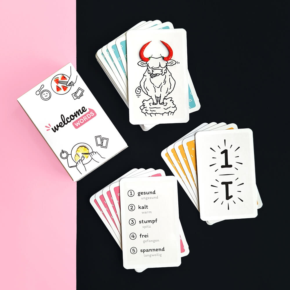 The Welcome Words box and three card stacks consisting of different card types, illustrations, numbers and words.